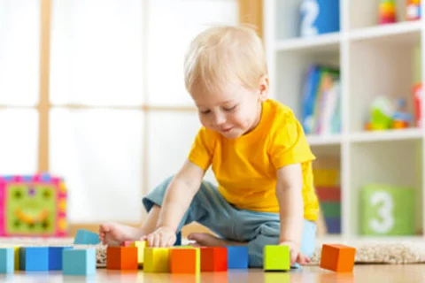 photo of a 18 month old boy playing with blocks